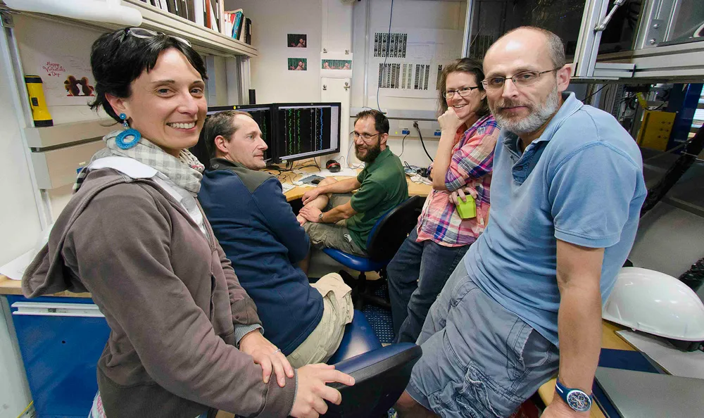 Scientists crowd around the stratigraphic correlators' screens. Co-chief scientists Sidney Hemming and Ian Hall are on the right. Photo: Tim Fulton/IODP