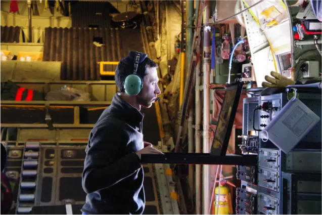 Flight Engineer Chris Bertinato monitoring the airborne instruments inside the LC—130 cargo hold. Photo Credit: Susan Howard