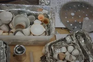 Bins of small white ceramic bowls used for burning samples.