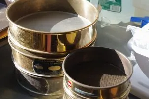 Two sieves, each made up of a metal cylinder with mesh screens 