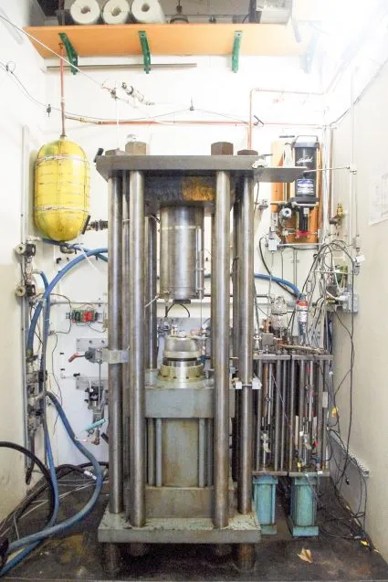 A big machine about the height of a person, with lots of metal tubes and pistons.