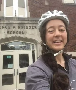 elizabeth hillary case with bike helmet in front of school