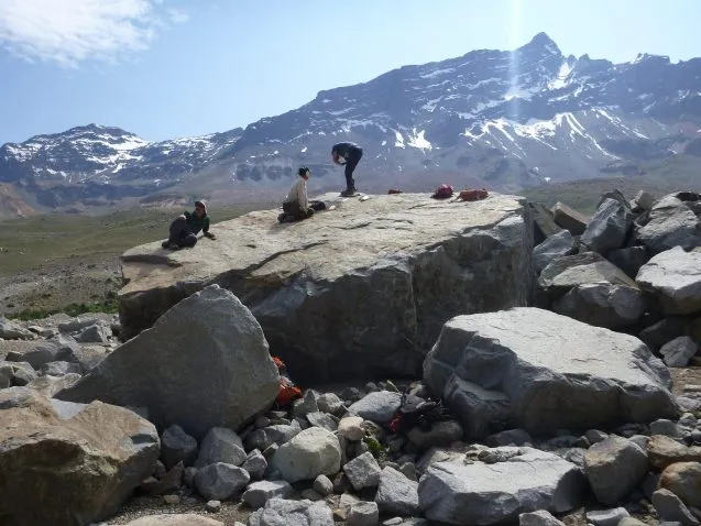 scientists sitting on large boulder