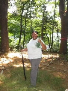 patterson holding a shotgun and a bunch of pine needles