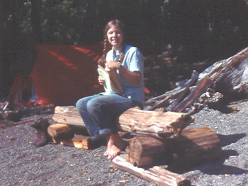 linda heusser sitting on a log with notebooks